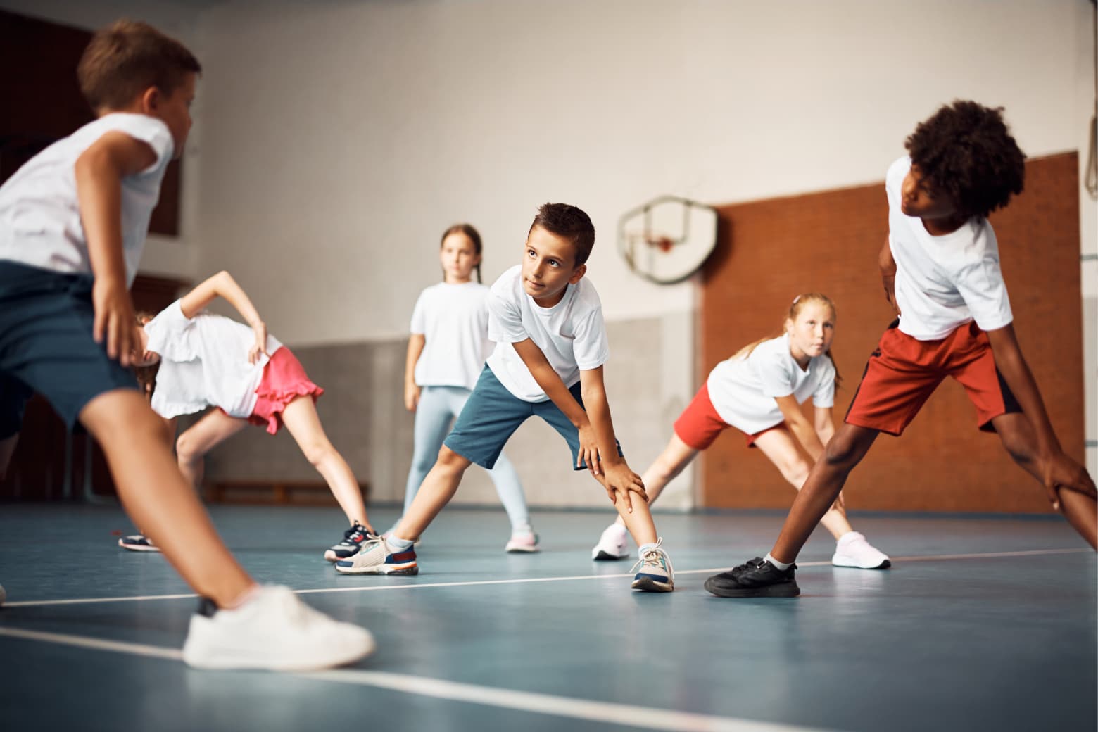 Enfants en échauffement musculaire dans un gymnase